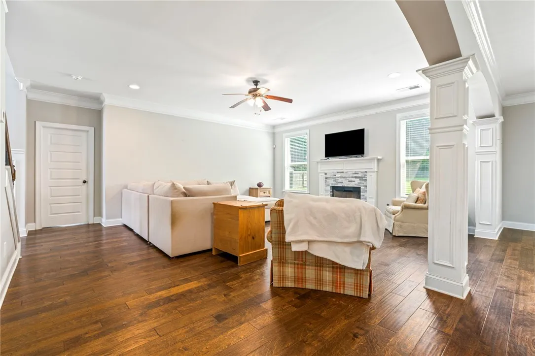 Rich hardwood floors lead to an inviting living area with a fireplace and natural light.