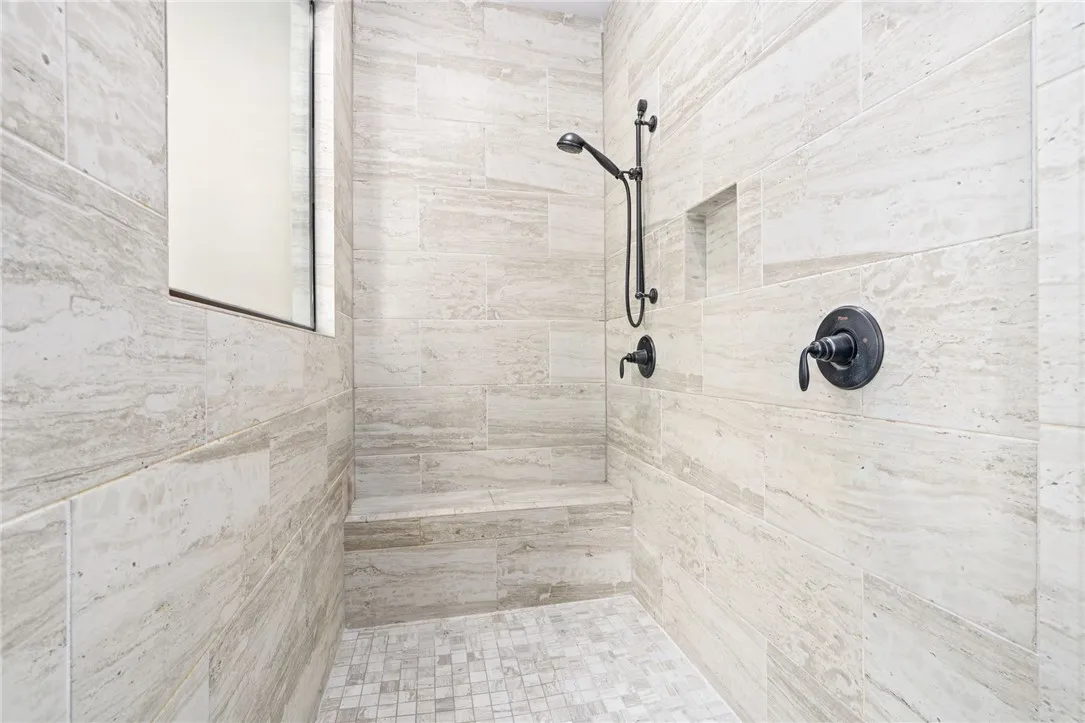 Enjoy the convenience of a built-in shower seat and stylish dark bronze fixtures.