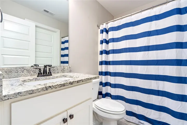 A well-appointed bathroom with a spacious vanity, framed mirror, and a full shower-tub combination.