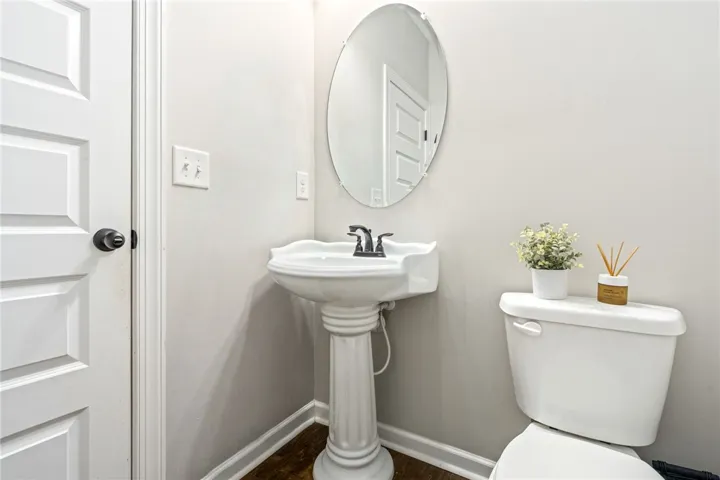 A well-appointed powder room features a classic pedestal sink and an oval mirror.