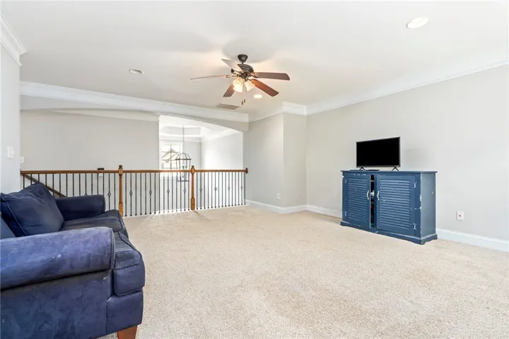 A spacious upper-level area offers versatile living space with a decorative railing overlooking the floor below.