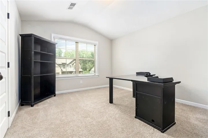 A quiet retreat with a vaulted ceiling and ample natural light, ideal for a home office.
