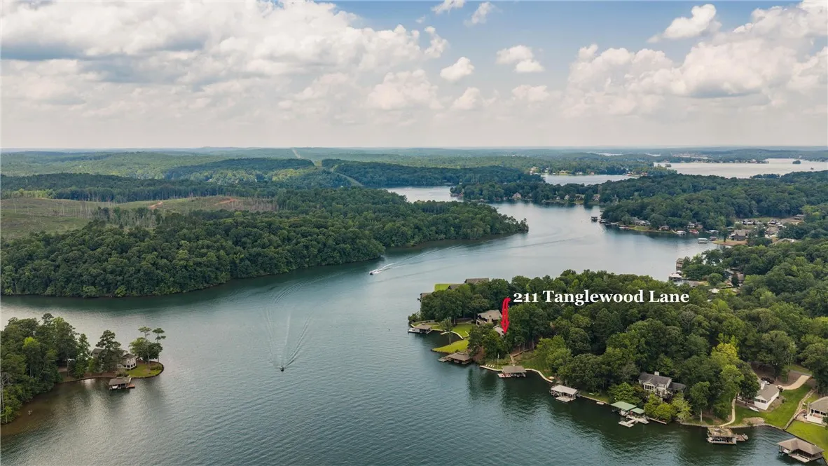 An aerial perspective reveals a serene waterfront home nestled among trees and calm waters.