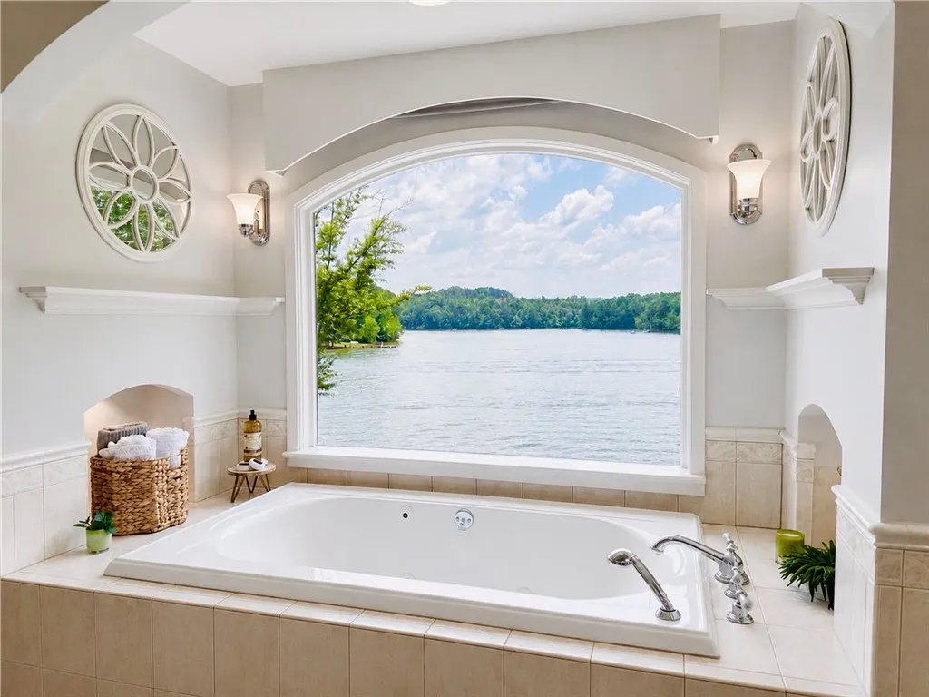 Framed by an elegant arched window, the main bathroom features an inviting soaking tub overlooking the lake.  Imagine relaxing in this spa like retreat and enjoying the best view in the house.