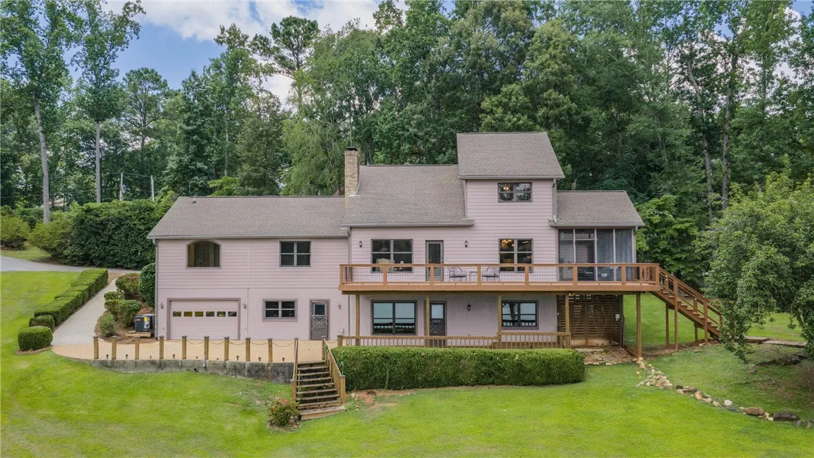 A spacious multi-level residence features an expansive deck and secluded backyard surrounded by mature trees.