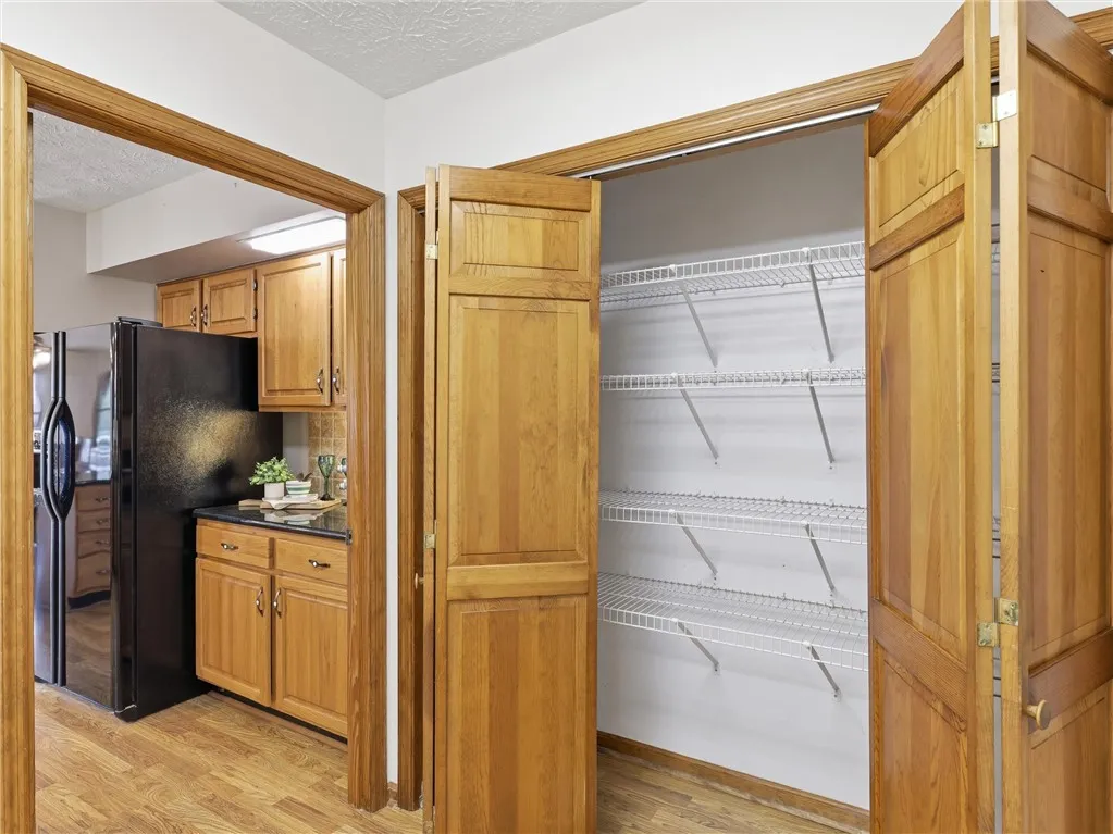 A convenient pantry with wire shelving provides ample storage adjacent to the functional kitchen.  This pantry is located in the laundry room.