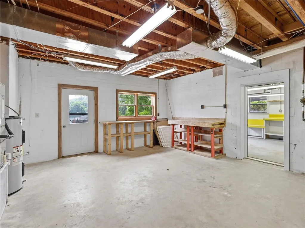 This spacious utility room provides ample space for projects and storage.  There is also an exterior door to the lake, a utility sink and extra storage.  The one car garage is just on the other side.
