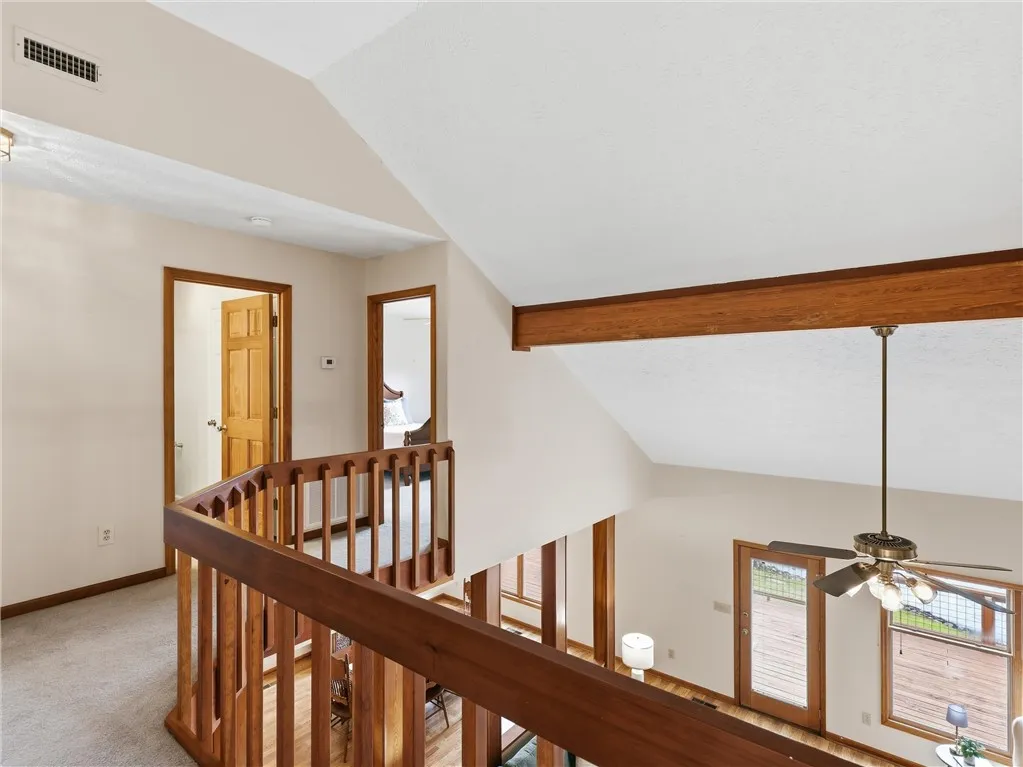 Overlooking the main living space, this hallway boasts warm wood railings.
