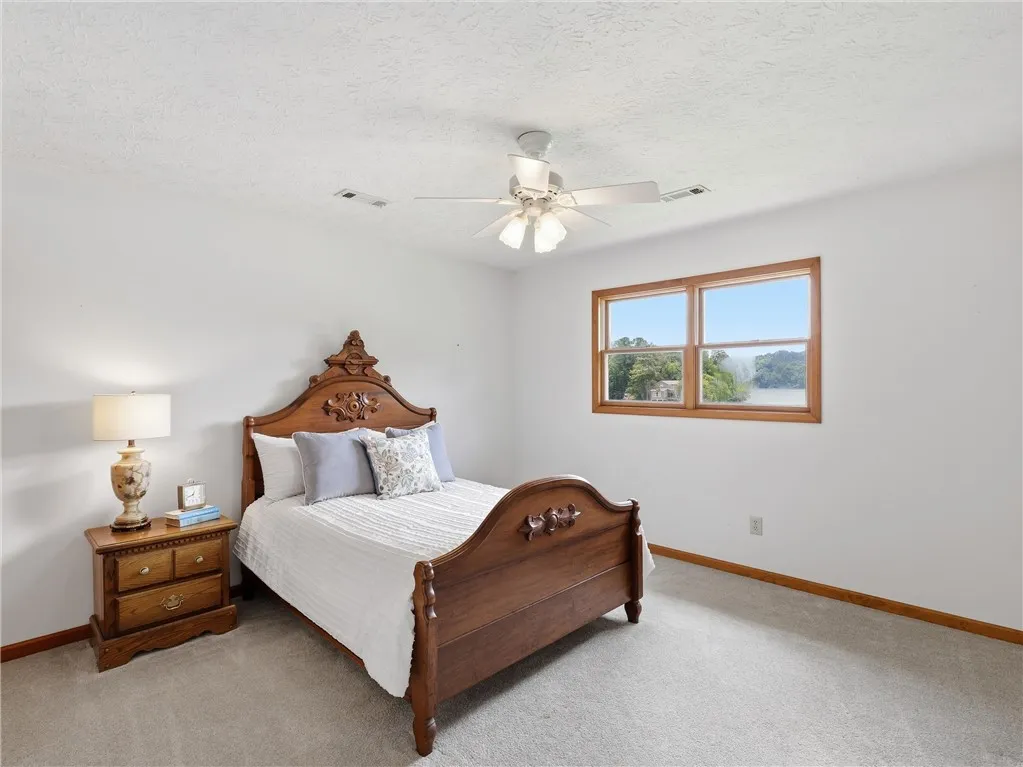 Upstairs, you will find two bedrooms, a nap room and a full bath.  This lake side bedroom offers well-lit sleeping quarters with serene natural views.