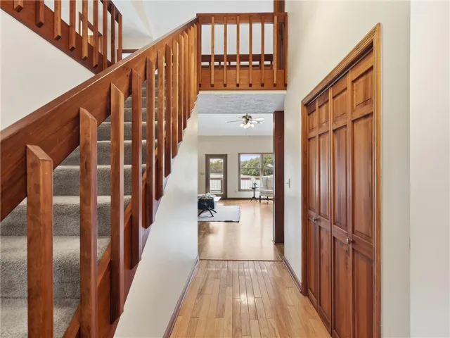 Natural wood tones grace the staircase and interior doors, leading to an open living area with scenic outdoor views.