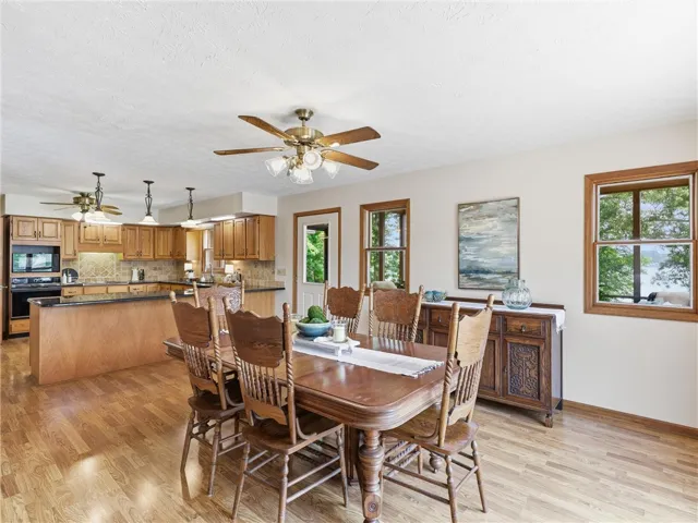 Hardwood floors flow through this dining area, complemented by abundant natural light from multiple windows.