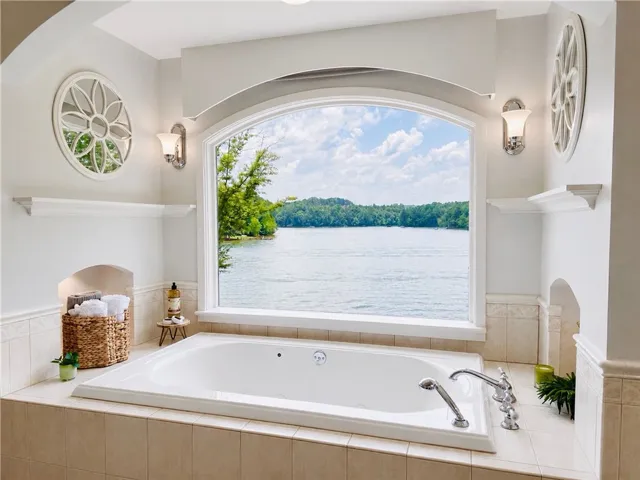 Framed by an elegant arched window, the main bathroom features an inviting soaking tub overlooking the lake.  Imagine relaxing in this spa like retreat and enjoying the best view in the house.