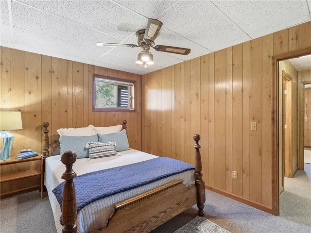 Just off the downstairs living room are two bedrooms and a freshly painted full bath. A comforting retreat, this bedroom offers a warm ambiance with rich wood paneling.