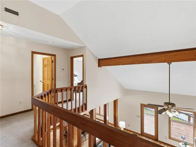 Overlooking the main living space, this hallway boasts warm wood railings.