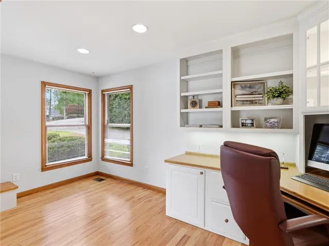 A dedicated home office space with built-in cabinetry and ample natural light, ideal for productivity.