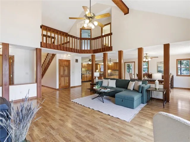 The great room features soaring vaulted ceilings, a large wood beam and a catwalk that leads to the upstairs bedrooms and bathroom.