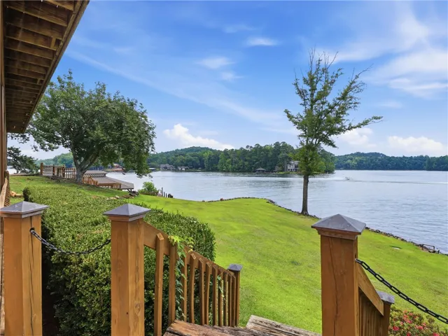 A picturesque lakefront setting, featuring rolling green lawns and direct water access, awaits your private retreat.