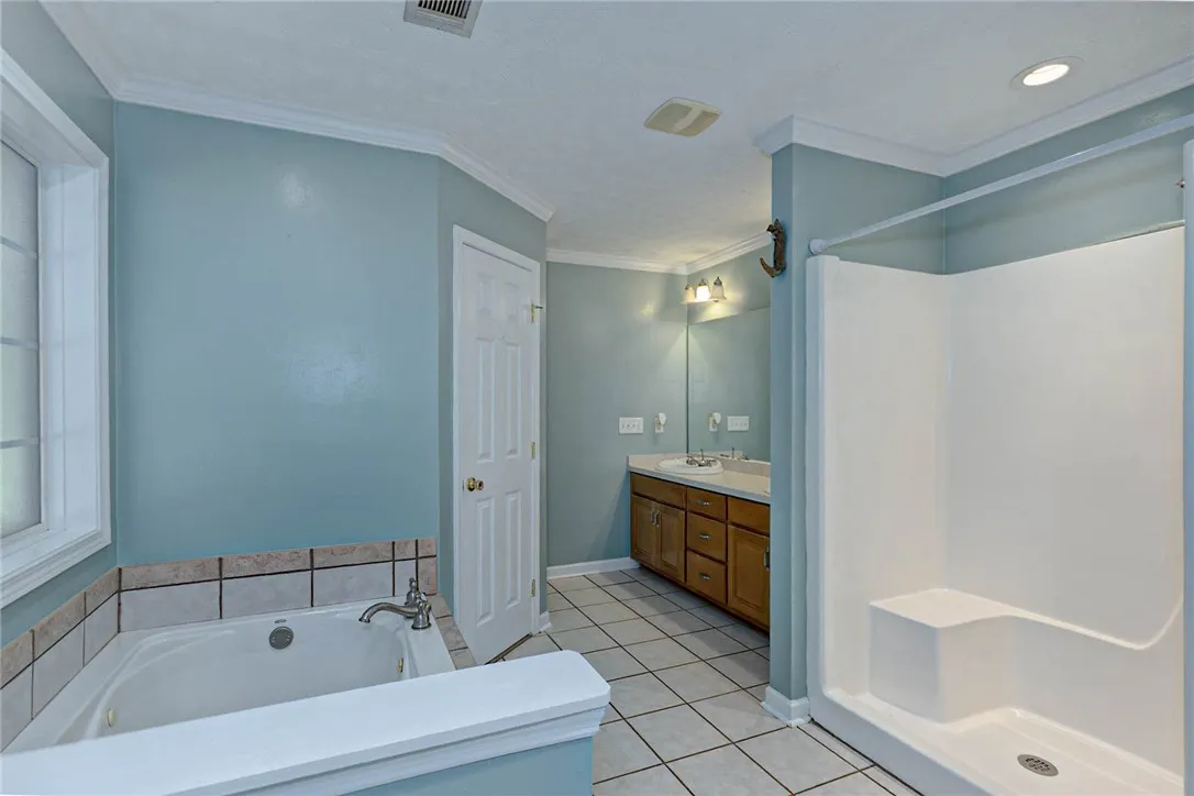 Indulge in a primary bathroom offering a soaking tub, separate shower, and double vanity.