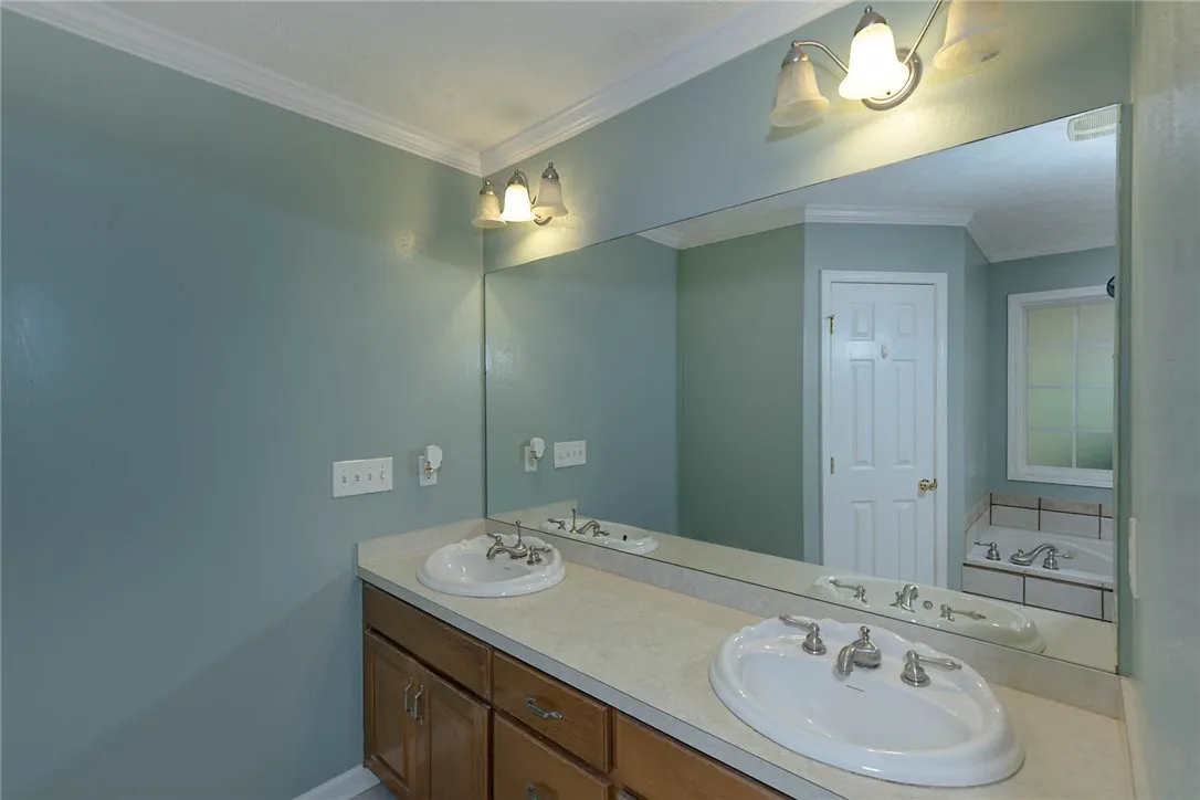 Double vanity with ample counter space creates a functional and organized primary bathroom.