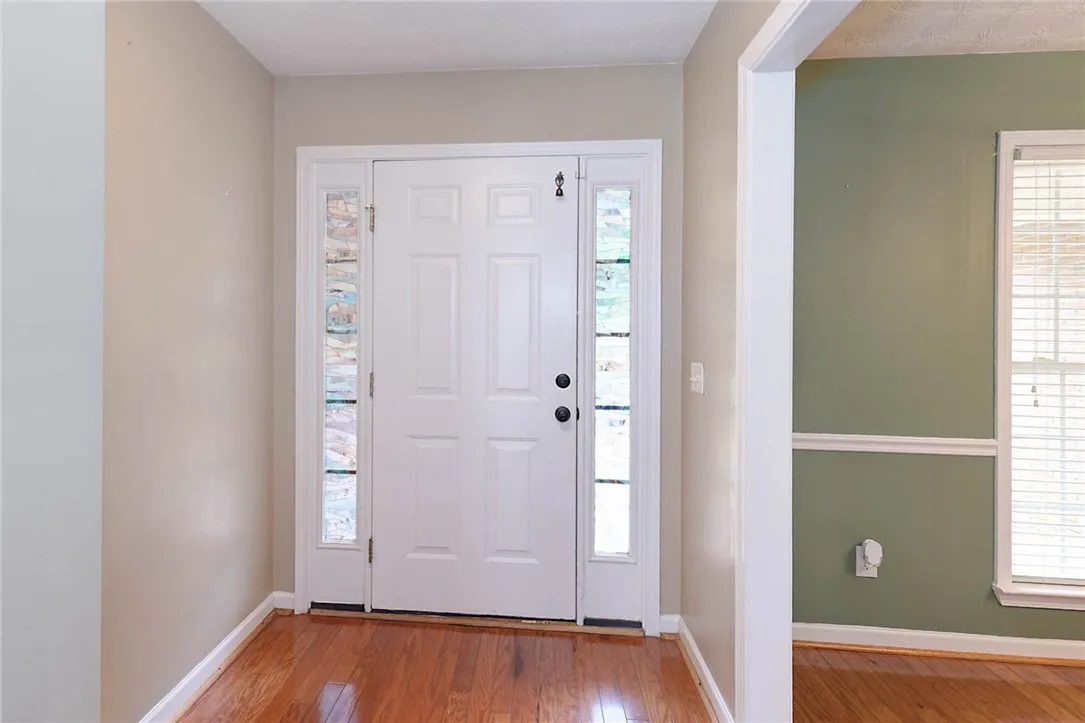 A welcoming entry features gleaming hardwood floors and art glass sidelights, inviting you further into the home.