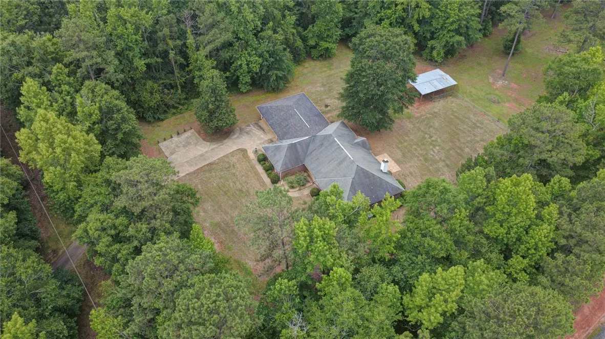 An aerial perspective reveals a secluded estate nestled within a verdant, mature treed lot.