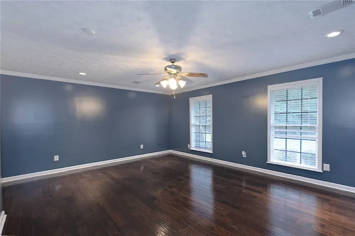 Rich hardwood floors complement the deep wall tones in this inviting living area.
