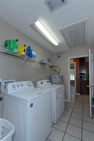 Functional laundry room featuring a washer, dryer, and tile flooring for effortless upkeep.