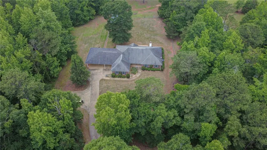 Perched amidst a verdant landscape, a tranquil single-story residence awaits, offering privacy and charm.
