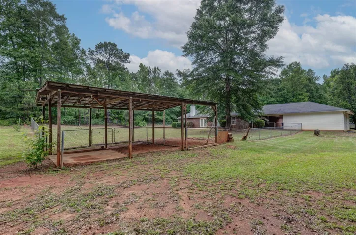 A spacious, fenced property with a functional shelter and ample open land.