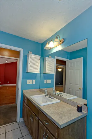A classic single vanity with ample counter space and mirrored walls defines this bathroom.