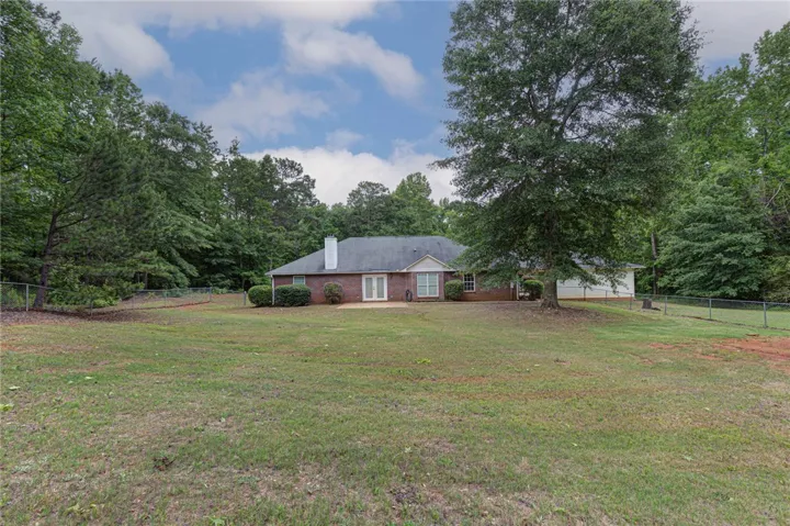 A spacious backyard with mature trees and ample green space, perfect for outdoor activities.