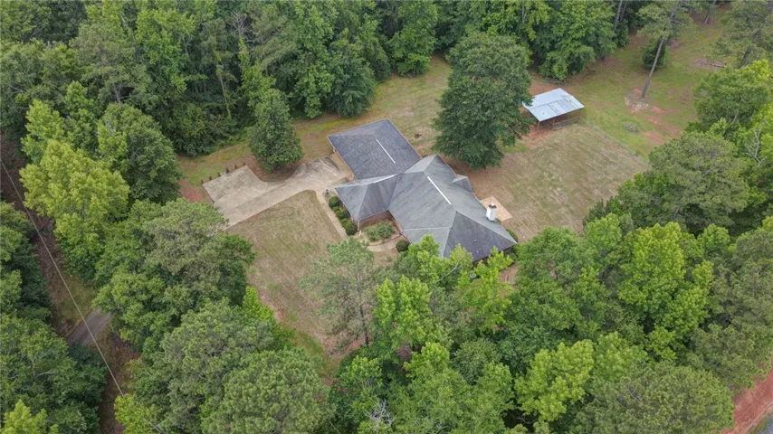 An aerial perspective reveals a secluded estate nestled within a verdant, mature treed lot.