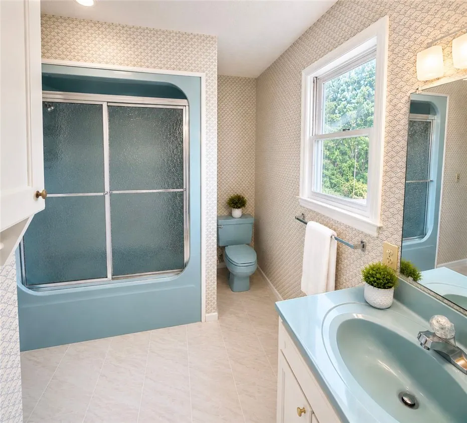 A well-lit bathroom features a vibrant blue tub and matching fixtures, creating a cohesive design.
