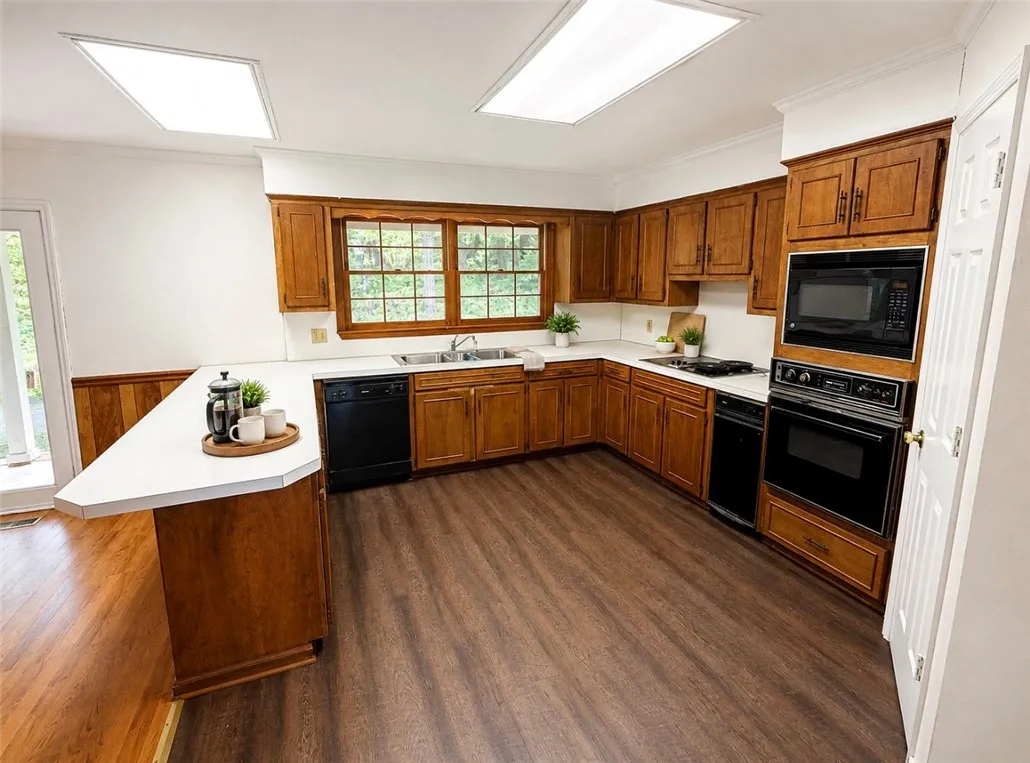 A well-lit kitchen with classic wood cabinetry and durable flooring invites culinary creativity.