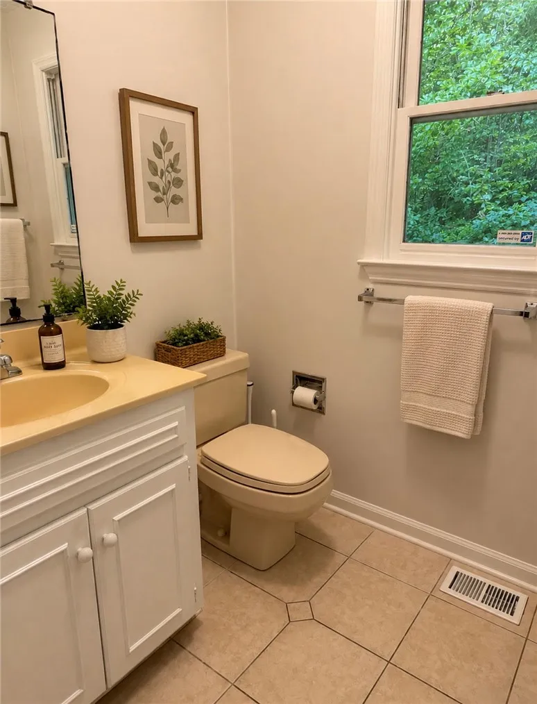 A well-appointed bathroom offers practical vanity storage and natural light through a window.