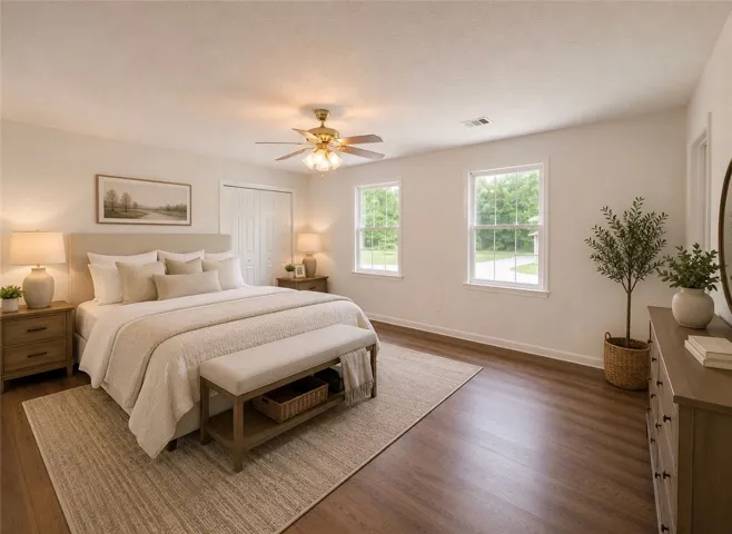 Hardwood floors and a ceiling fan enhance this cozy bedroom, creating a peaceful retreat.