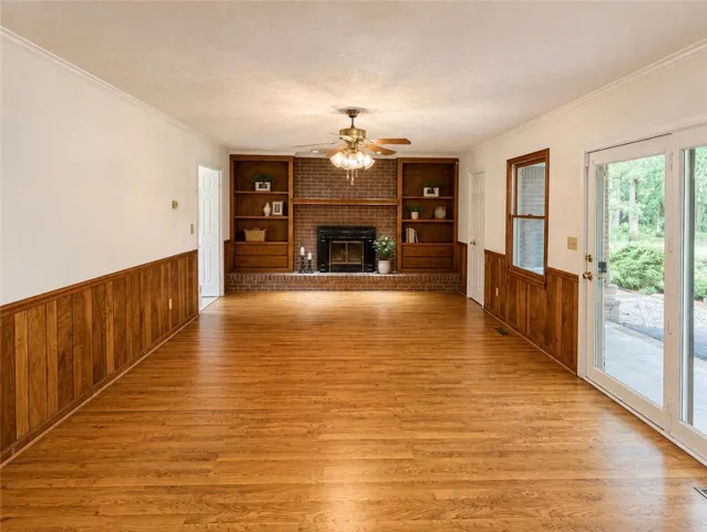 A warm and inviting living space with rich hardwood floors and a classic brick fireplace.