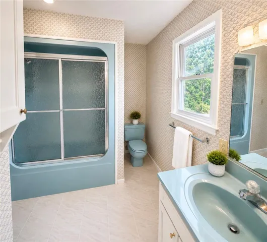 A well-lit bathroom features a vibrant blue tub and matching fixtures, creating a cohesive design.