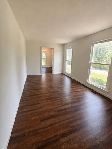 Rich hardwood floors extend through this airy living space with ample natural light.