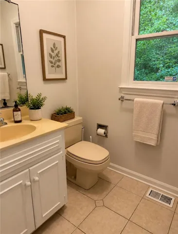 A well-appointed bathroom offers practical vanity storage and natural light through a window.