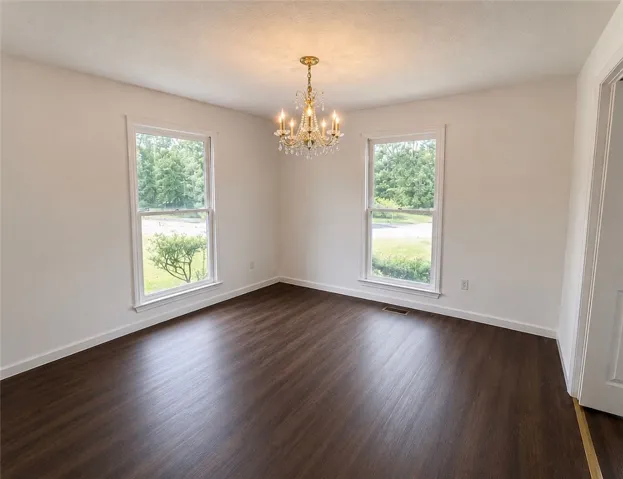 A refined crystal chandelier illuminates this inviting space with rich wood flooring.