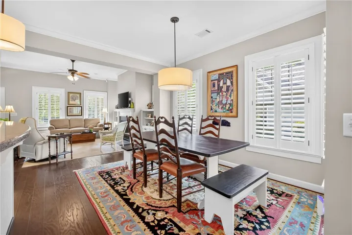 Hardwood floors and a stylish area rug define this welcoming dining area, open to a sun-filled living space.