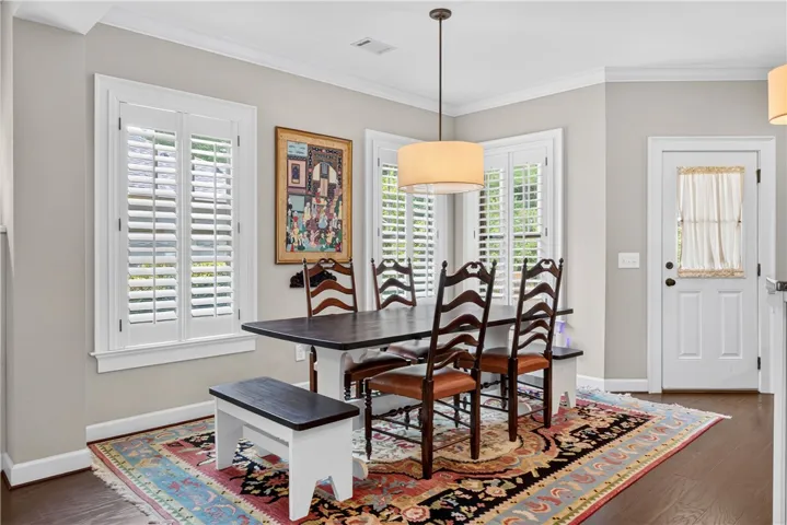 Hardwood flooring and plantation shutters define this inviting dining area, ideal for relaxed meals.