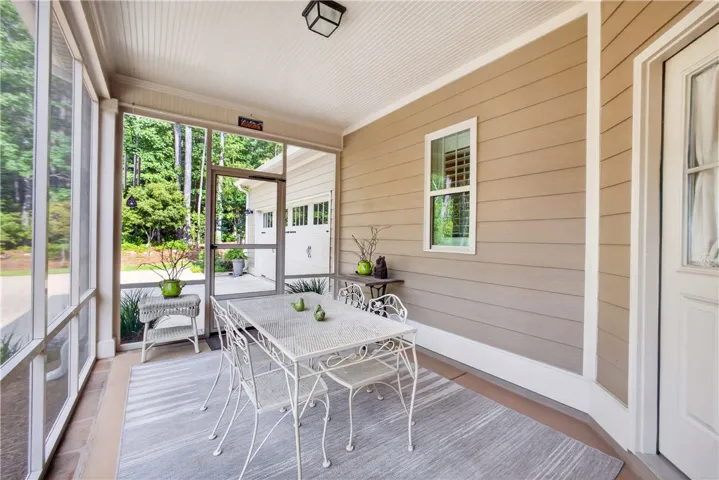 A tranquil screened porch offers verdant views and an inviting space for relaxation.