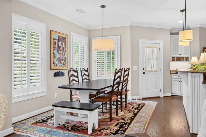 Hardwood floors and bright windows create an inviting dining area, ideal for gathering.