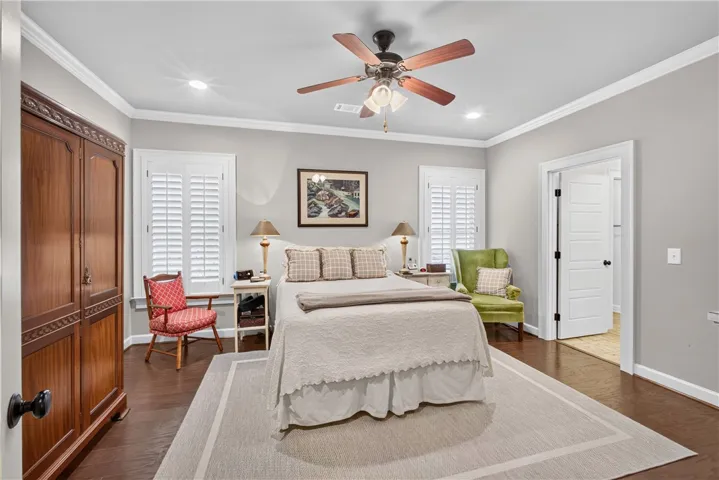 Well-lit sleeping quarters with rich hardwood floors and classic plantation shutters.