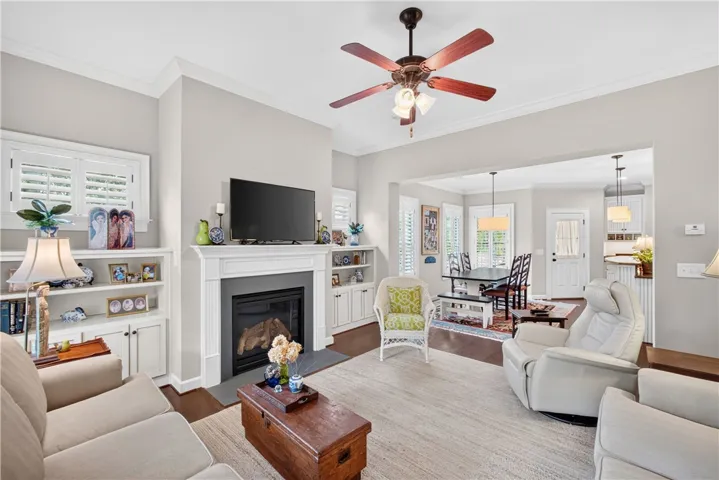 A classic fireplace with an elegant mantel anchors this bright living space with rich hardwood floors.