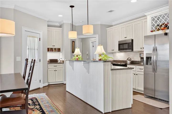 A well-appointed kitchen features rich hardwood flooring and a functional kitchen island for culinary endeavors.