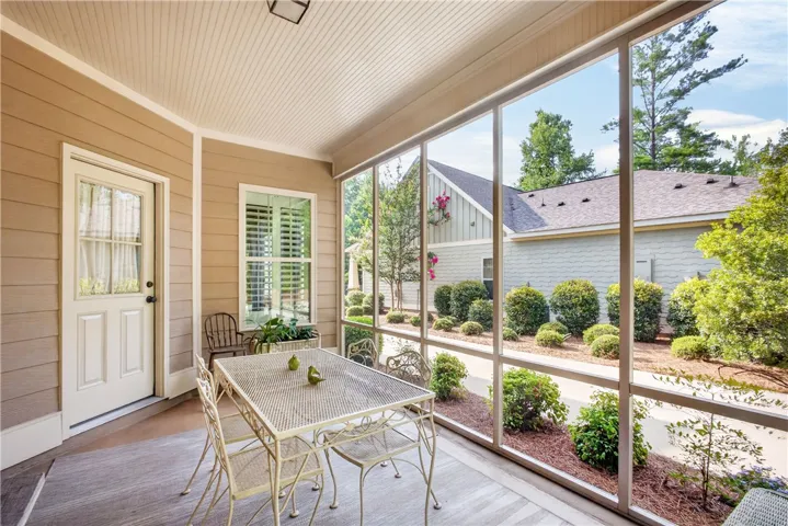 Enjoy the outdoors year-round from this delightful screened porch, offering serene garden views.