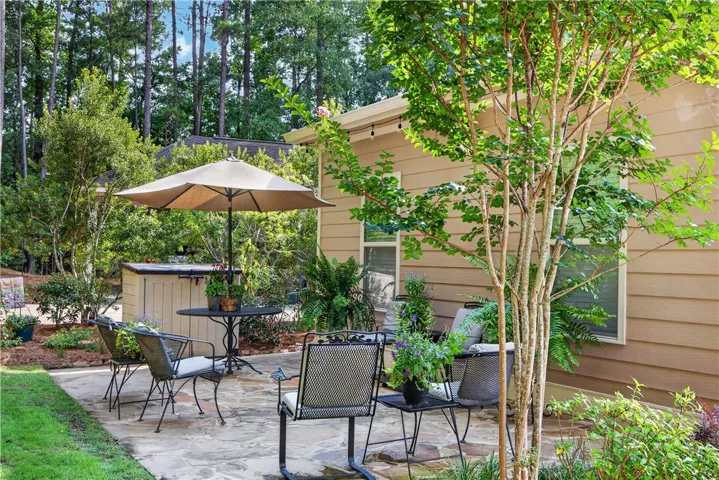 An inviting stone patio offers a private outdoor retreat surrounded by verdant landscaping.